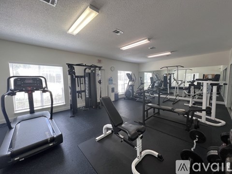 A gym with treadmills, weights, and exercise equipment.