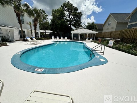 A pool with a blue tinted water and a white fence around it.