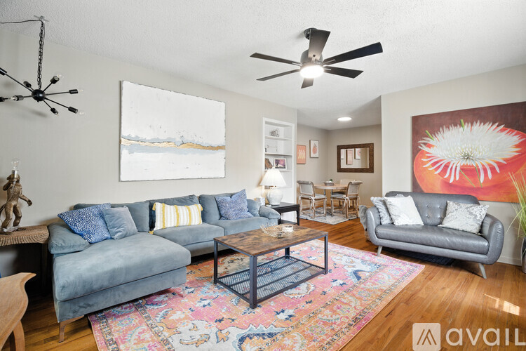 A living room with a couch, chair, and rug.