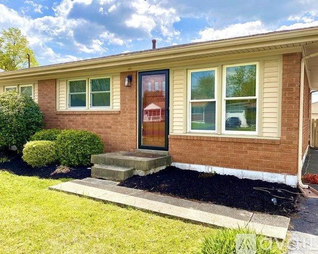 A house with a red door and a small front yard.