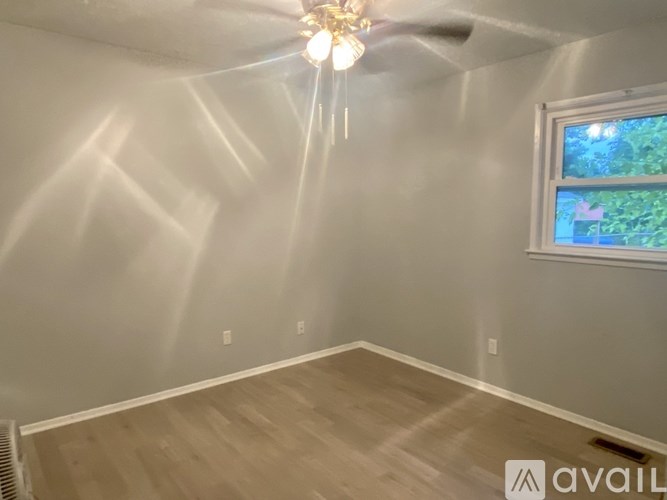 A room with a ceiling fan and a window overlooking a fish tank.