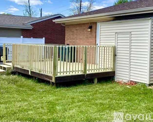 A wooden deck with a white fence and a white garage door.