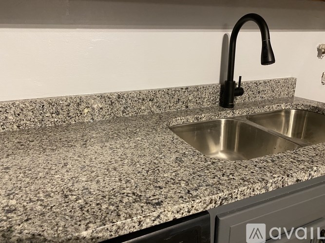 A granite countertop with a sink and a black faucet.