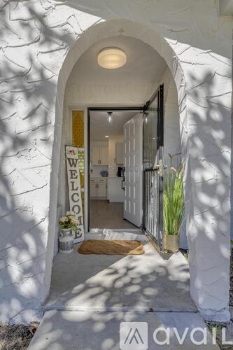 A white building with a "Welcome" sign on the door.