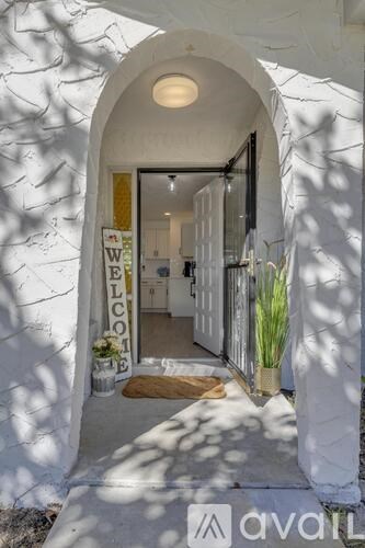 A white building with a "Welcome" sign on the door.