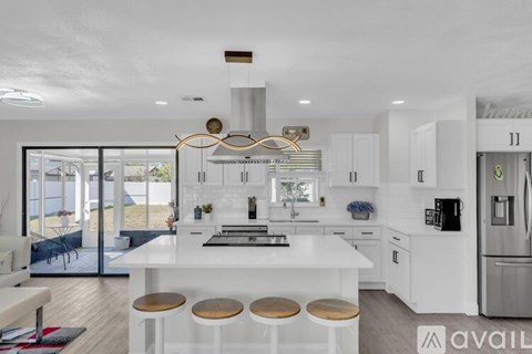 A modern kitchen with white cabinets and a large island.