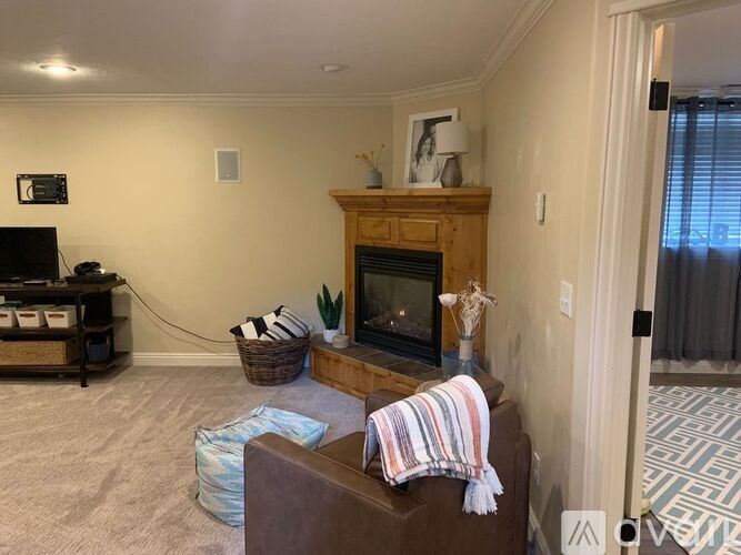 A living room with a fireplace and a brown couch.