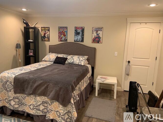 A bedroom with a bed, a nightstand, and a wall-mounted fan.