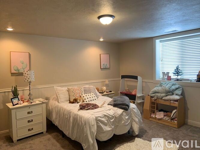 A bedroom with a bed, nightstand, and a window with blinds.