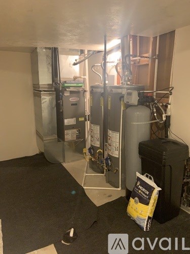 A room with a heating unit and a bag of Avail on the floor.