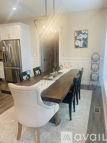 A dining room with a wooden table and chairs.