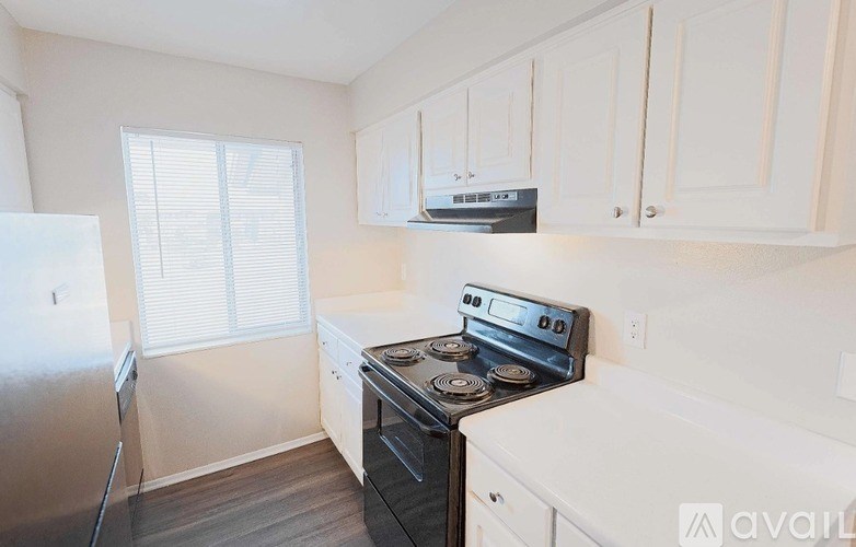 A kitchen with white cabinets and a black stove top oven.