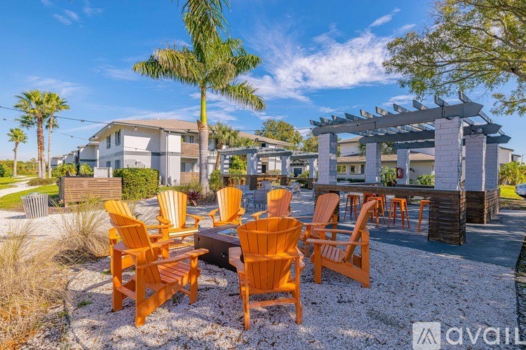 A sunny day at a beachfront property with chairs and a table set up for outdoor dining.