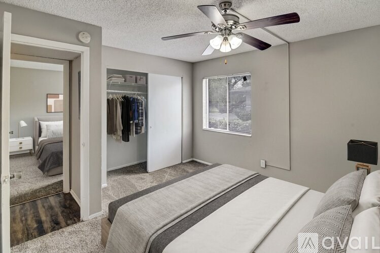A bedroom with a bed, a ceiling fan, and a closet.