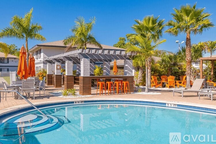 A pool area with a clear blue sky and palm trees.