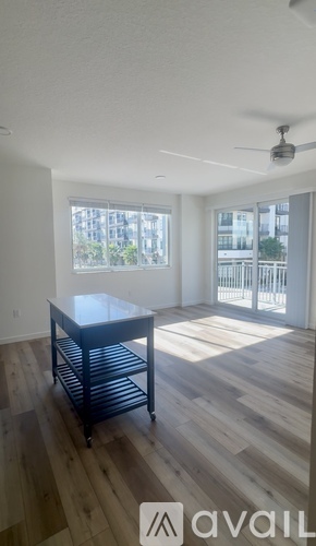 A spacious room with a sliding glass door leading to a balcony.