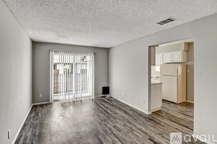 A spacious room with a sliding glass door leading to a balcony.