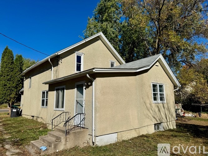 A beige house with a grey roof and a small front porch.