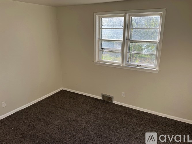 A room with a carpeted floor and a window.