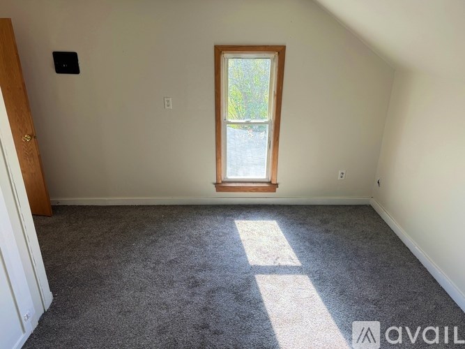 A room with a window and carpeted floor.