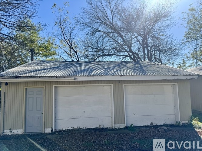 A house with a metal roof and two garage doors.