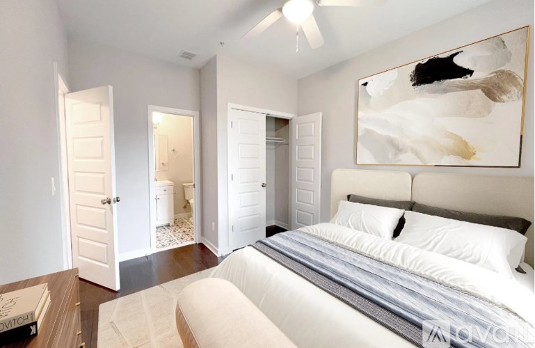 A bedroom with a large bed and a painting on the wall.