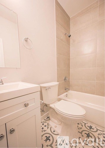 A white toilet sits next to a bathtub in a bathroom.