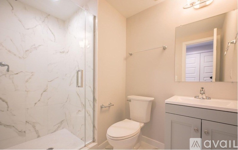 A bathroom with a marble wall and a toilet.