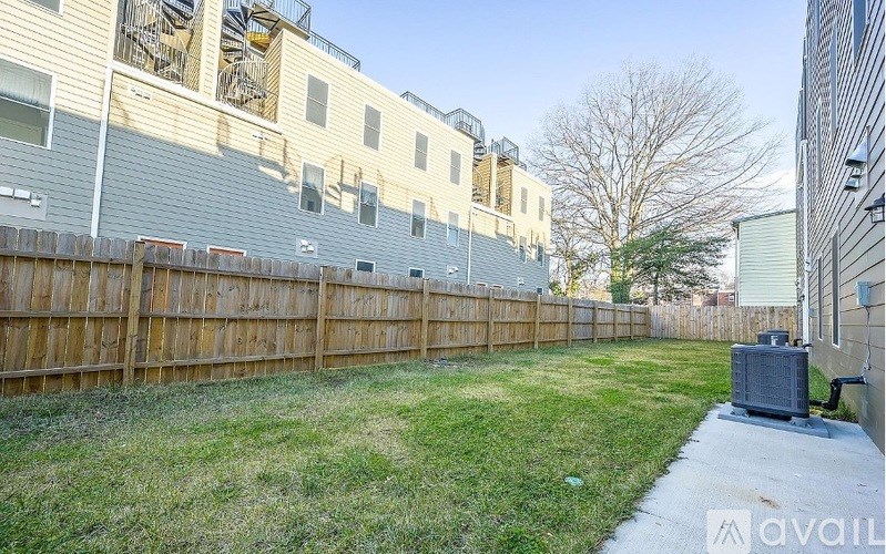 A backyard with a wooden fence and a green lawn.