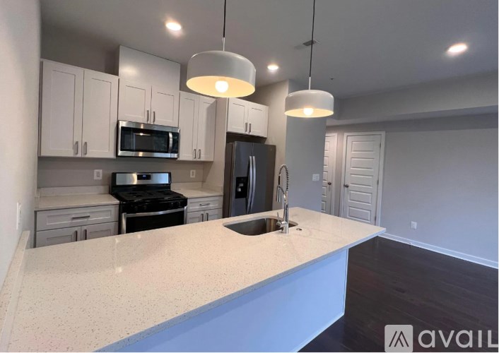 A kitchen with white cabinets and a black refrigerator.