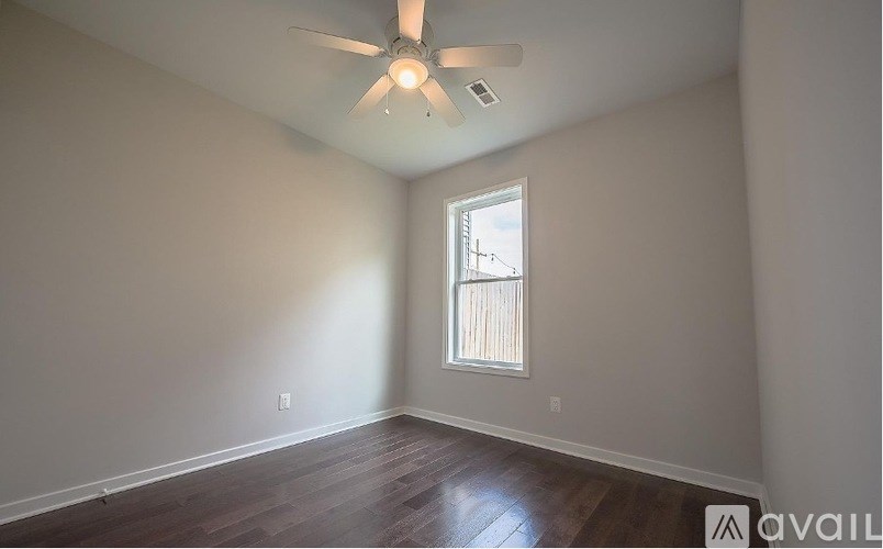 A room with a ceiling fan and a window with blinds.