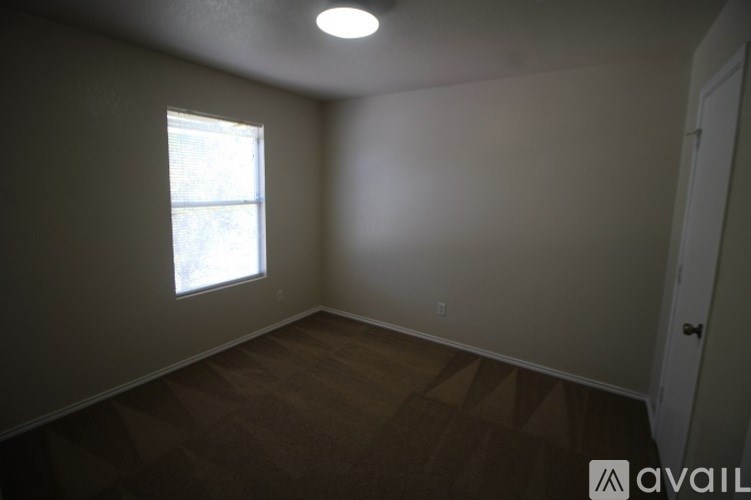 A room with a window and a door is available for rent.