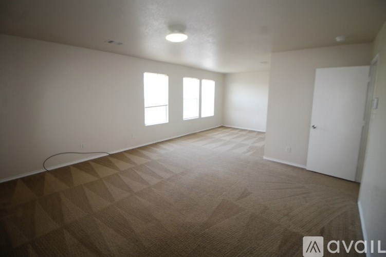 A room with a carpeted floor and a window.