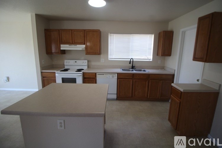 A kitchen with white appliances and wooden cabinets.