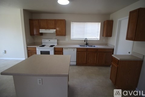 A kitchen with white appliances and wooden cabinets.