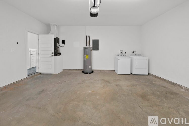 A room with a white wall and a door, a white fridge, and a white oven.