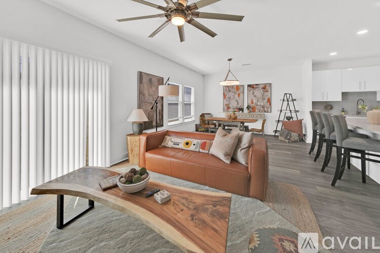 A modern living room with a brown leather sofa and a wooden coffee table.