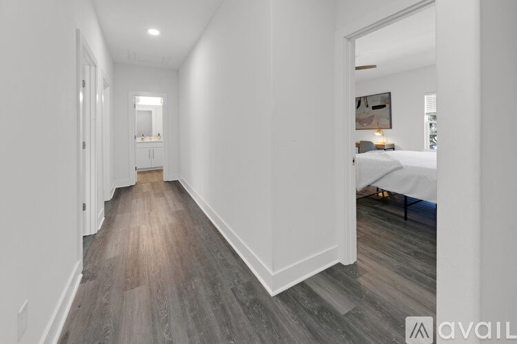 A long hallway with wood floors and white walls.