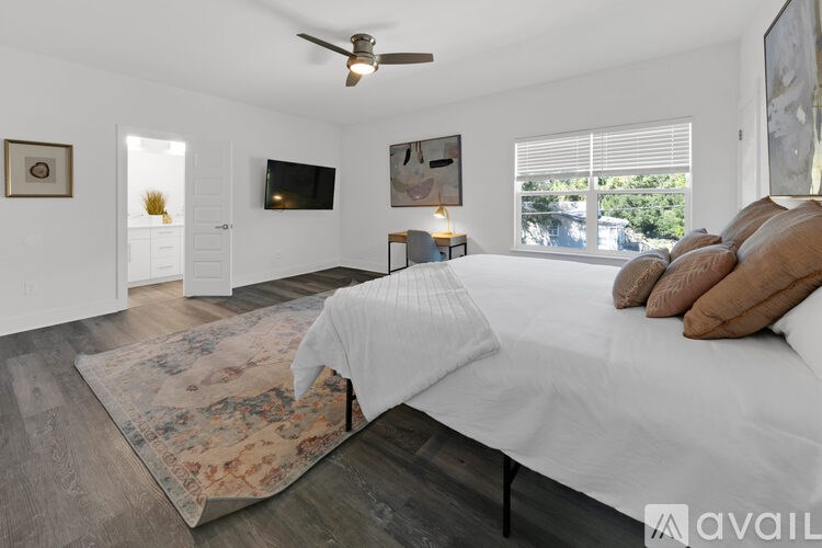 A bedroom with a large bed and a ceiling fan.