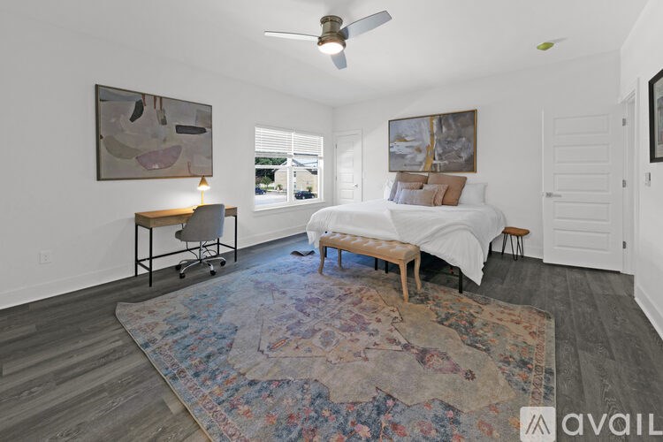 A bedroom with a bed, a chair, and a rug.
