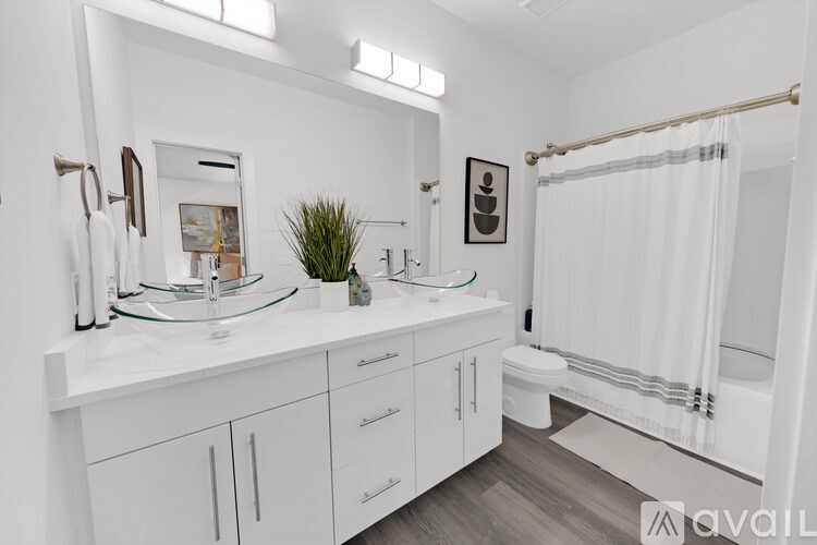 A bathroom with white cabinets and a white sink.