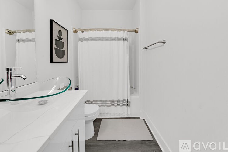 A bathroom with a white toilet, sink, and a white shower curtain.