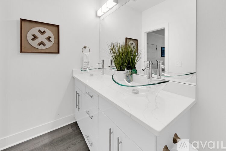 A bathroom with a white countertop and a framed picture on the wall.