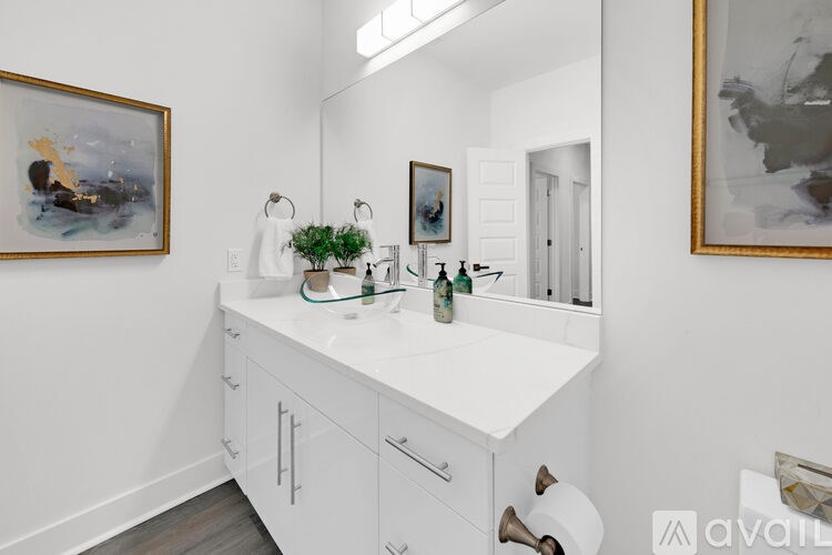 A bathroom with a white counter and a painting on the wall.