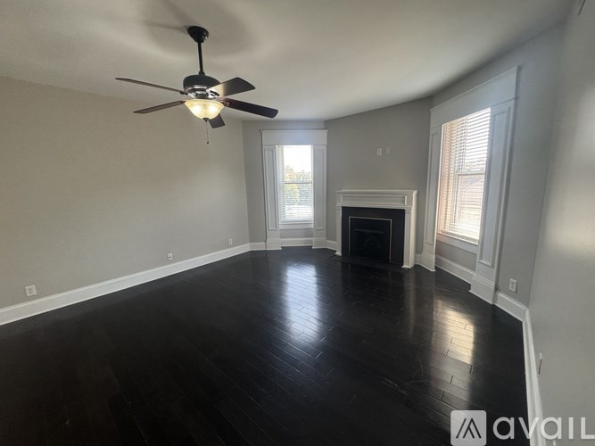 A room with a ceiling fan and a fireplace.