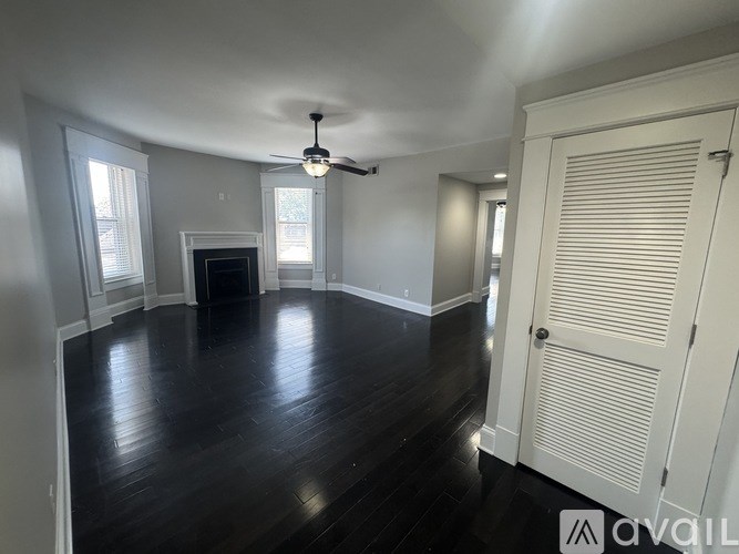 A room with a fireplace and a ceiling fan.