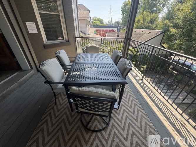 A table and chairs are on a patio with a view of a street.