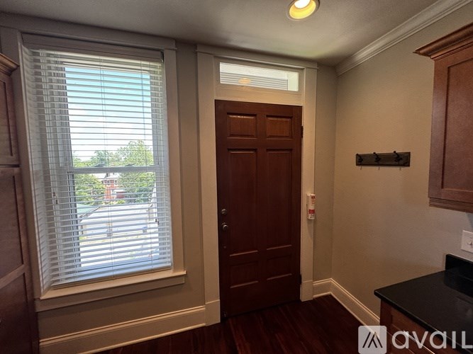 A bathroom with a white tub and black tiles.