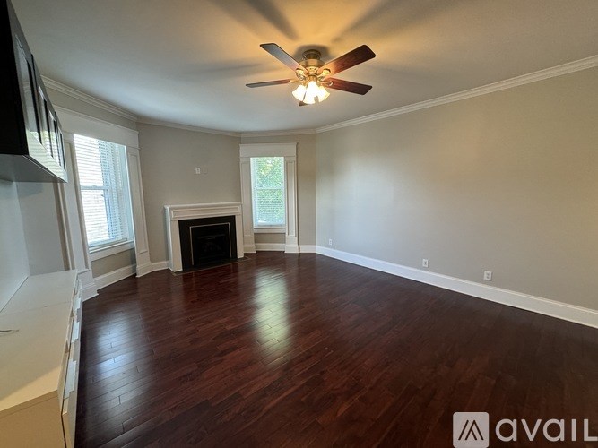 A white washing machine is in a small cabinet in a home.