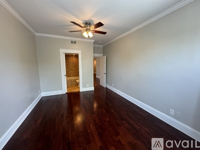 A kitchen with dark wood floors and white walls.